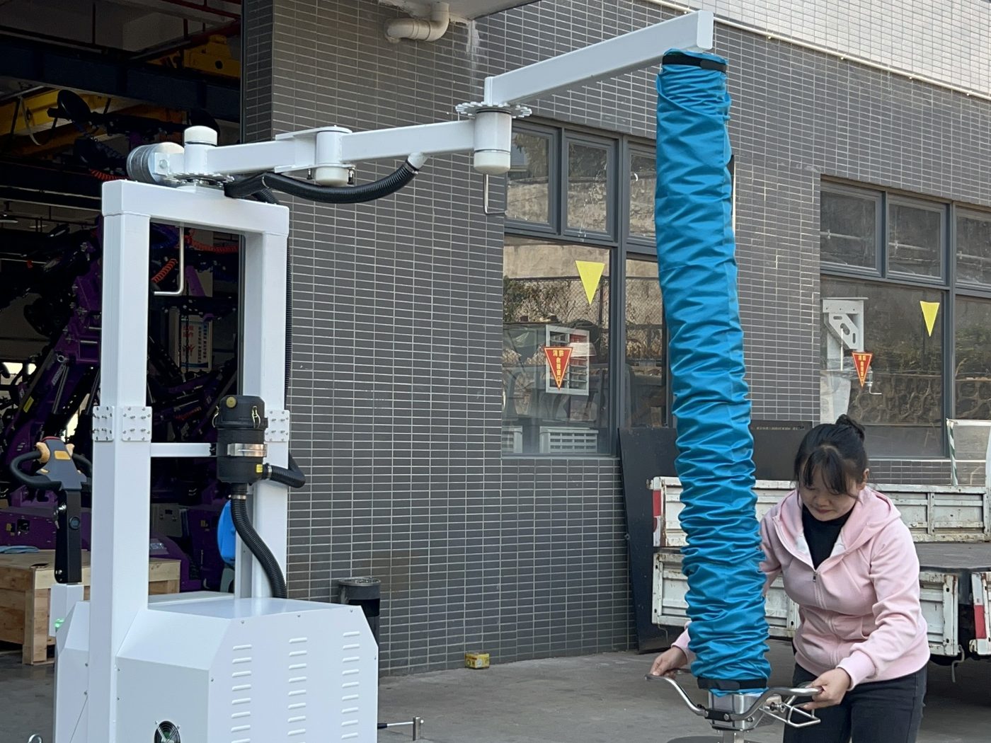 Mobile vacuum tube lifter working beside a loading bay
