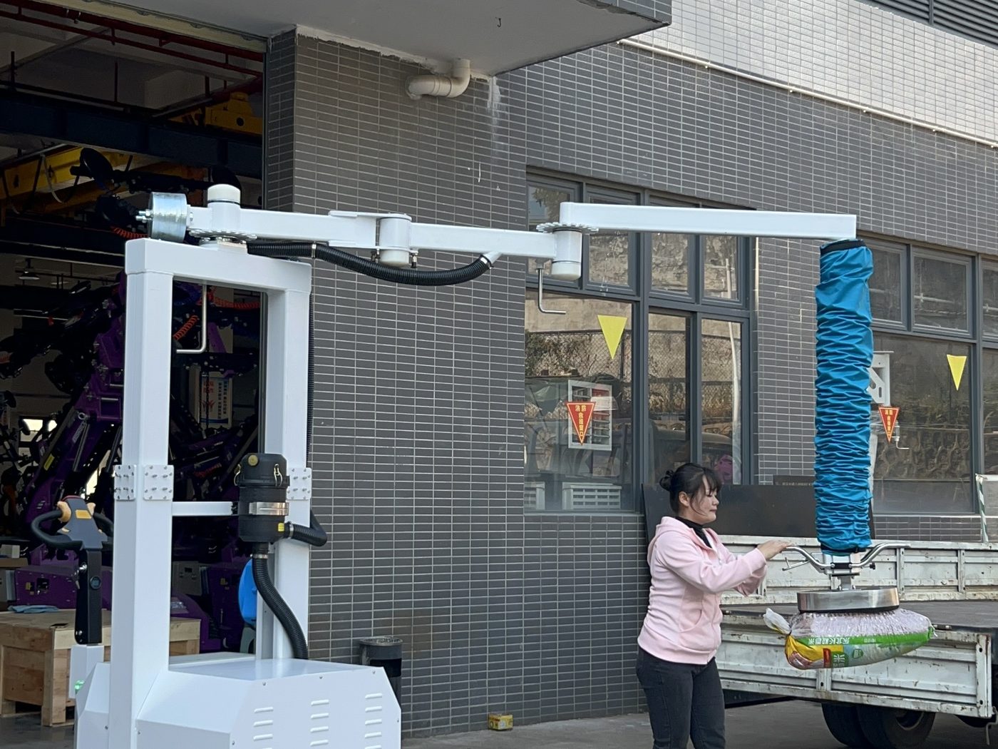 Operator guiding a mobile vacuum tube lifter outdoors