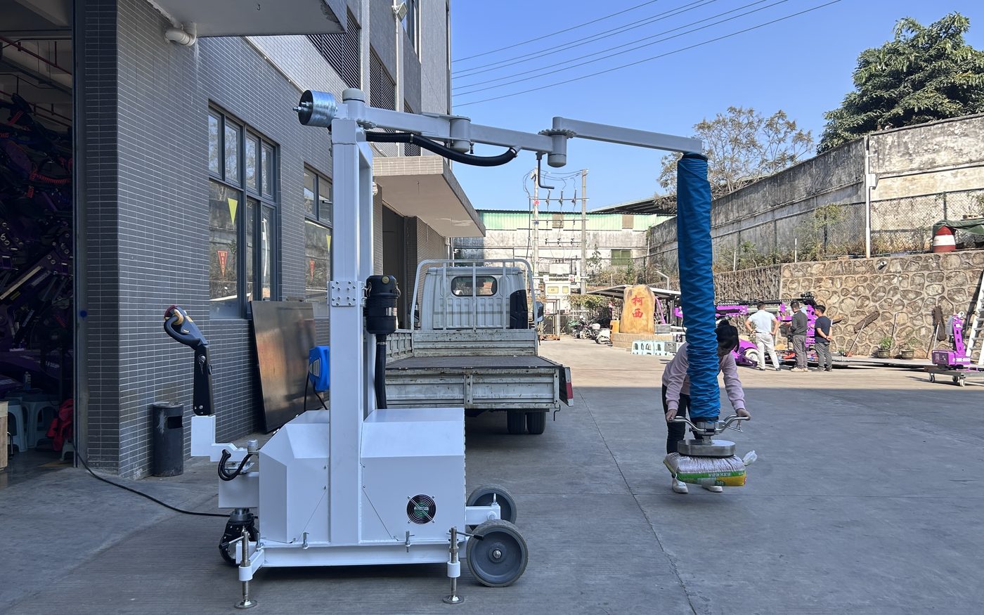 Mobile vacuum tube lifter unloading sacks in the factory yard